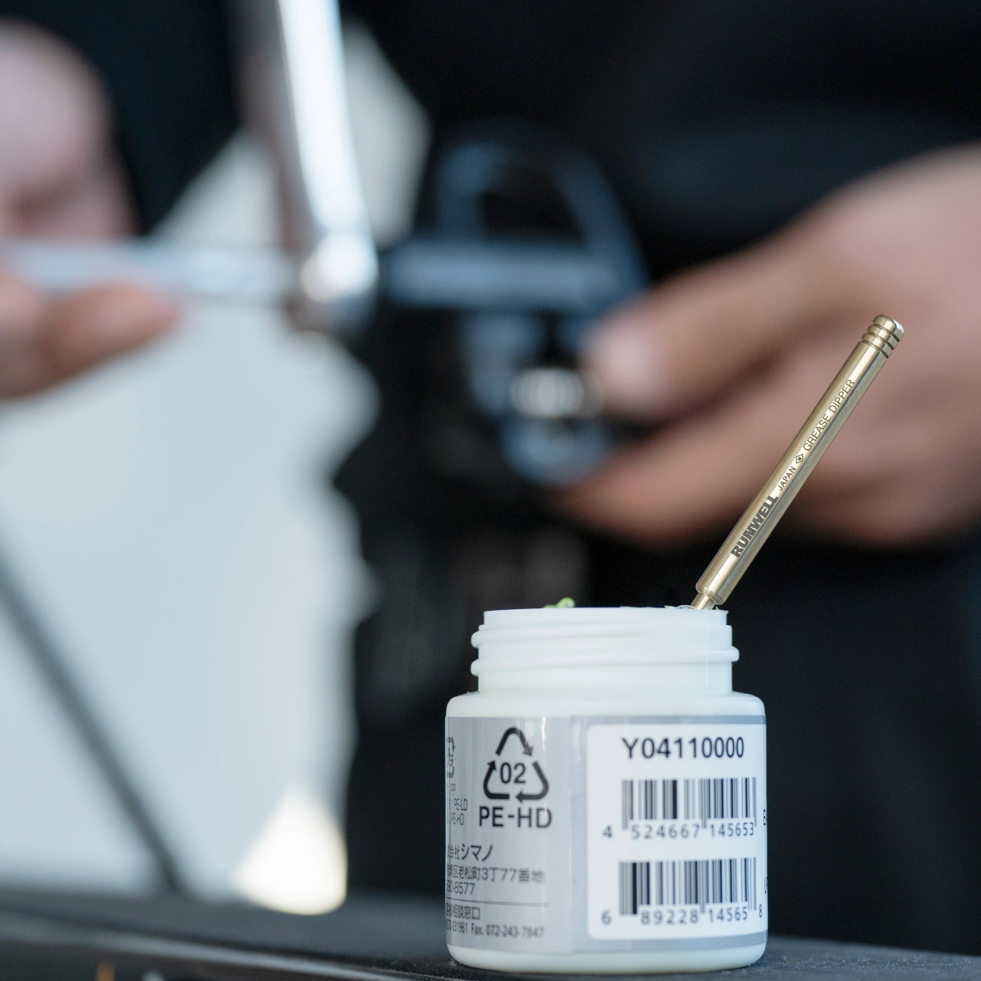 Grease dipper in a pot of shimano grease, color oxydized with age