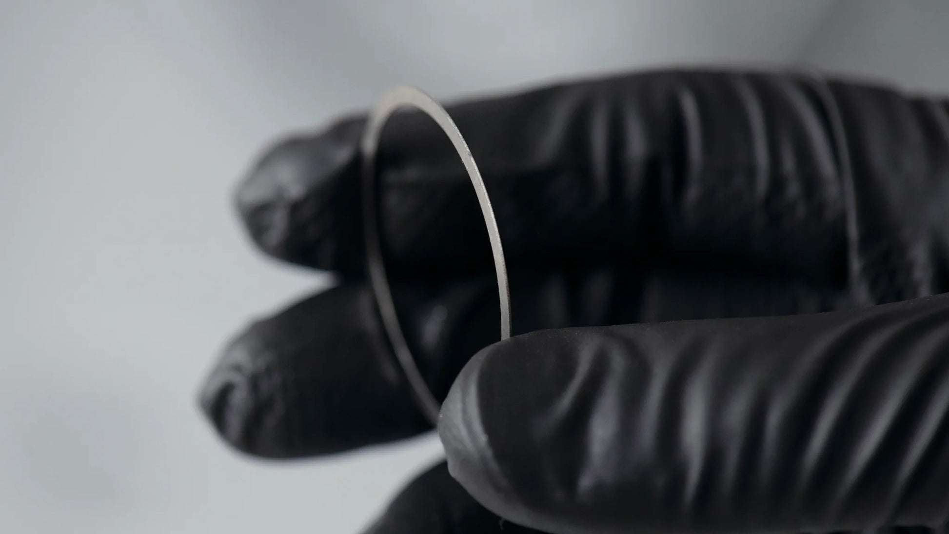 Hakurin stainless spacer scale look in a gloved mechanic hand