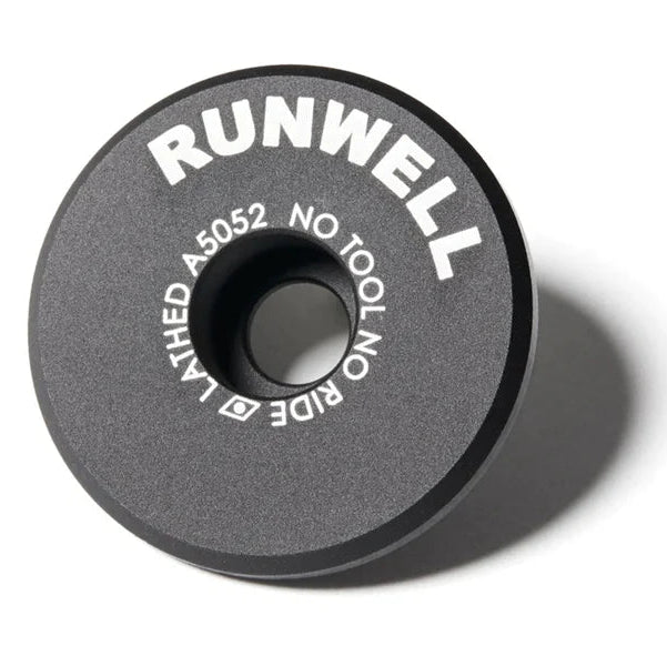 Close-up photo of the Runwell RW TOP CAP made of aluminum anodized black with the catchphrase Not Tool No Ride written on it