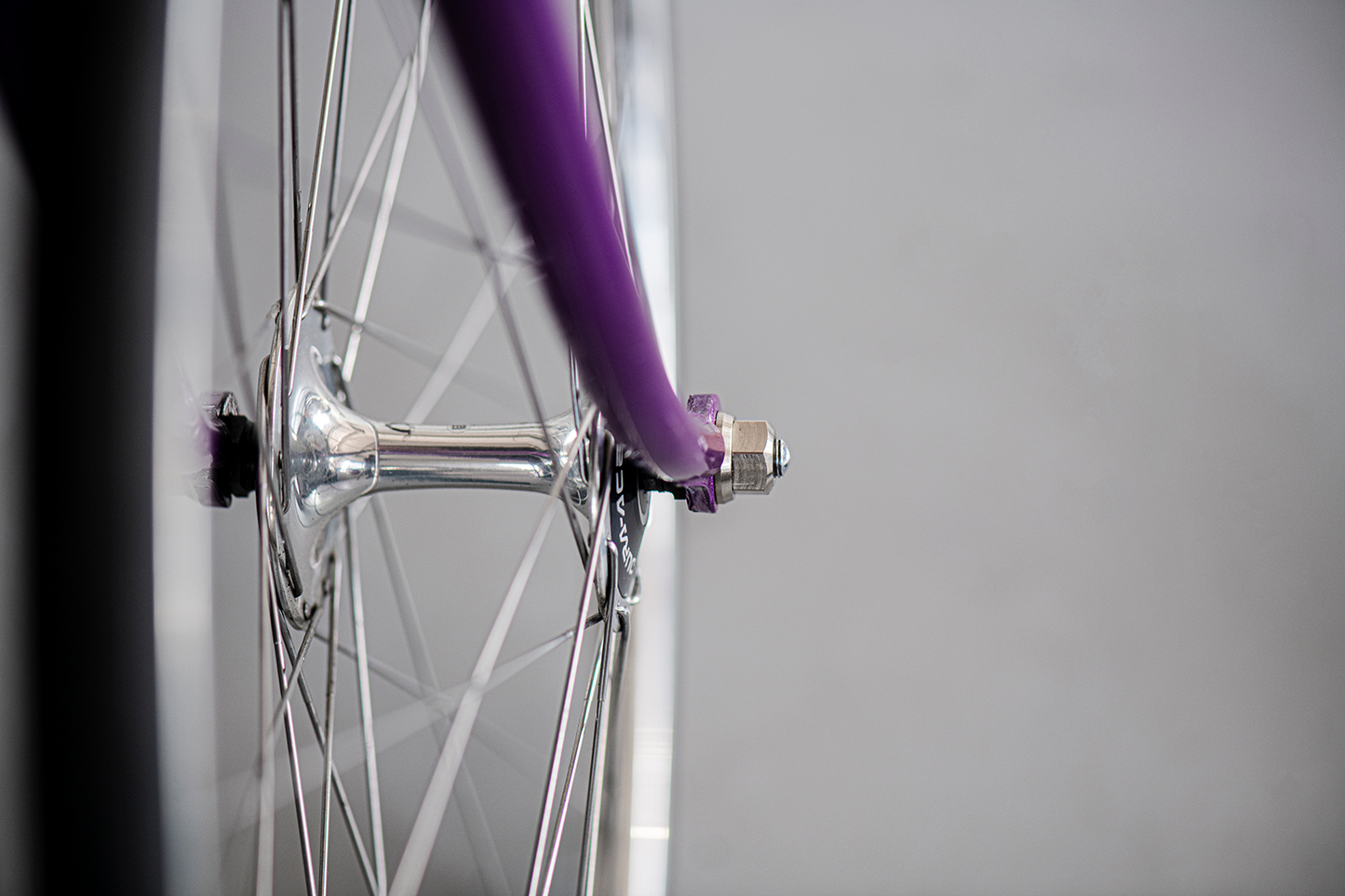 Perfomance track axle nuts by Runwell, M10, Black nut, Silver on a purple NJS bike fork